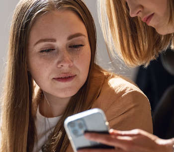 To kollegaer snakker sammen på kontoret