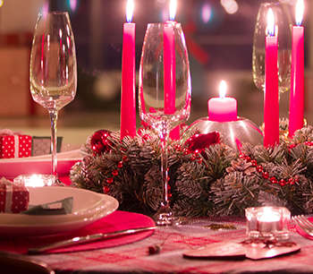 Bord dekket til julemiddag med juletre i bakgrunnen