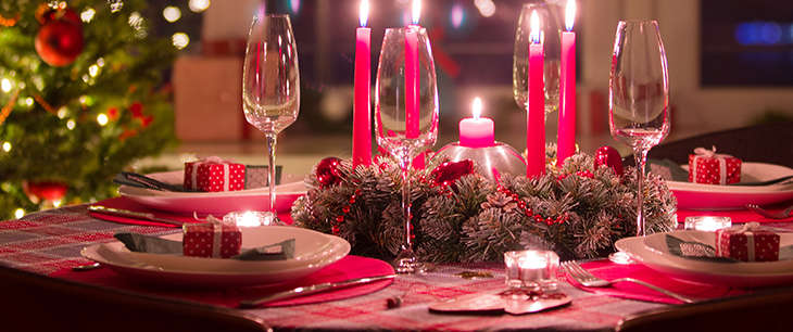 Bord dekket til julemiddag med juletre i bakgrunnen