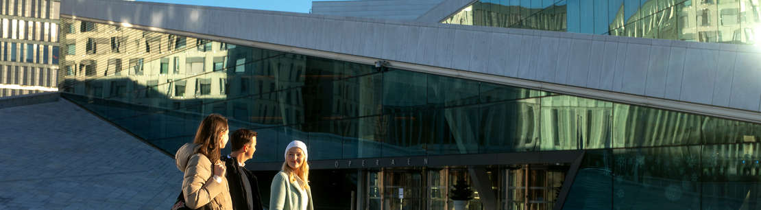 Tre personer går foran operaen i Oslo