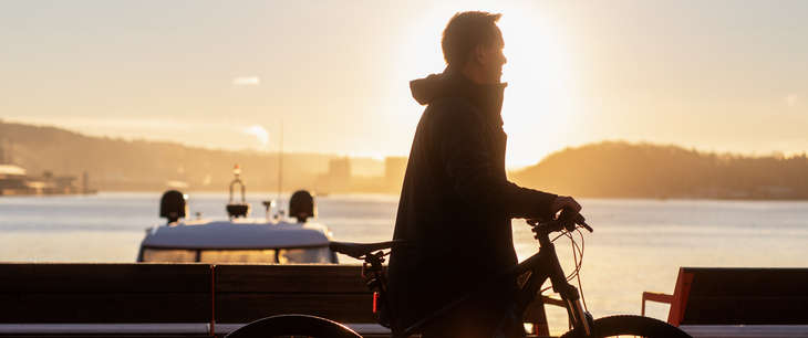 Mann triller en sykkel på Aker Brygge