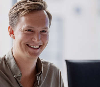 En ung mann smiler til en kollega