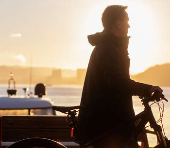Mann triller en sykkel på Aker Brygge