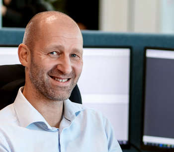Mann sitter foran pc-skjerm på et kontor