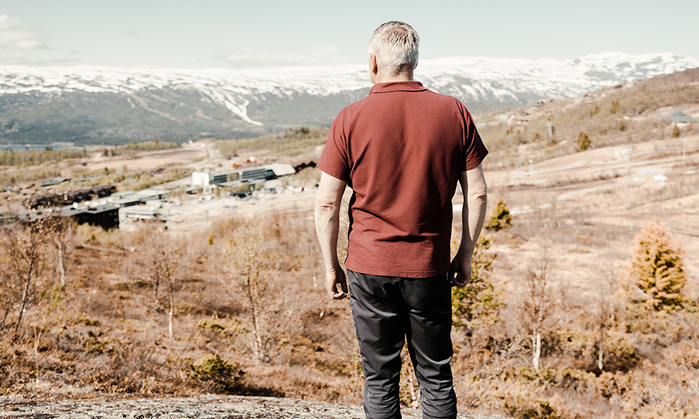 Mann ser utover landskap