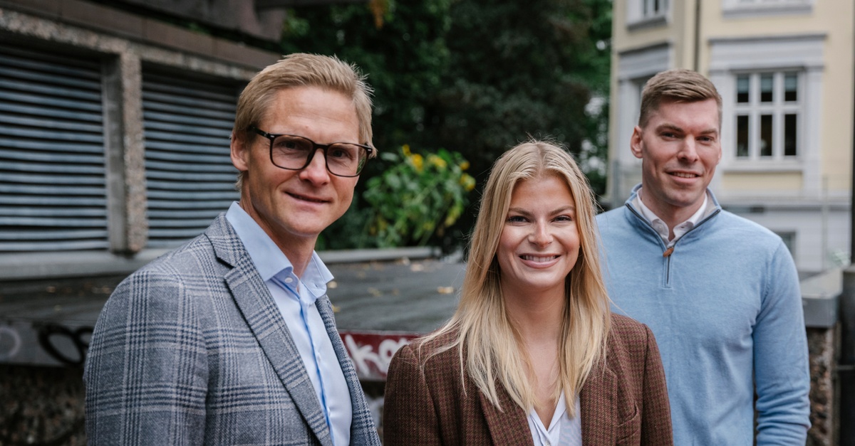 Tre personer står og smiler