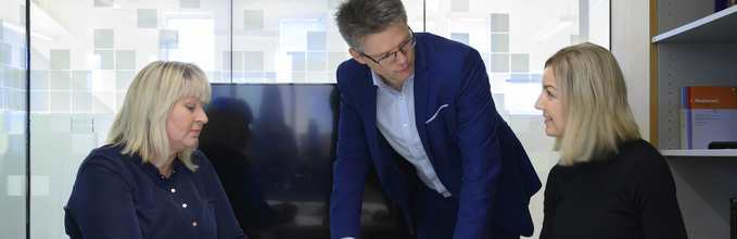 Bilde av tre personer som diskuterer