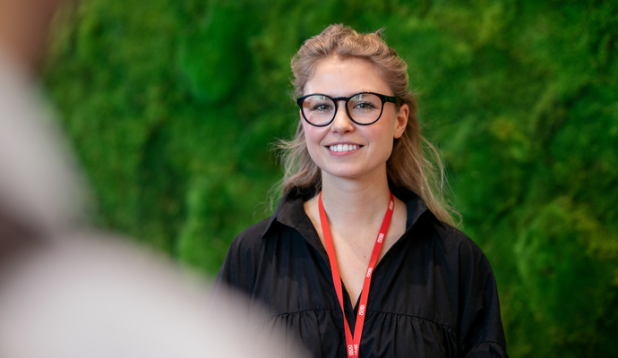 Kvinne foran grønn mosevegg