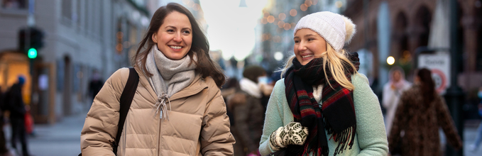 Illustrasjonsbilde av to smilende damer i en gate