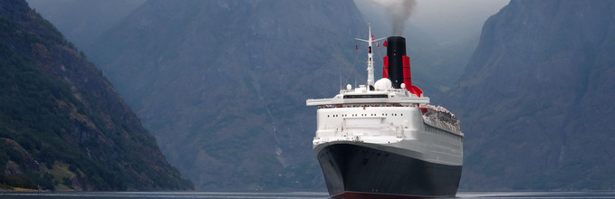 Bilde av et cruiseskip som seiler inn i en fjord